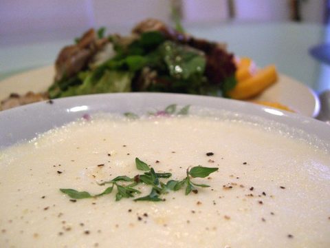 Representative photograph of Avgolemono Soup. The photograph includes another dish in the background, which is not part of this soup recipe.