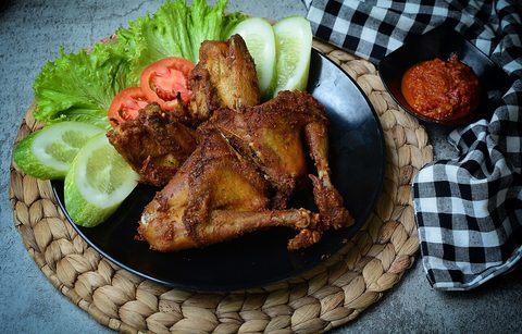 Representative photograph of Ayam Goreng. The photograph shows ayam goreng Kalasan with salad and sambal; this draft uses a simpler spice mixture.