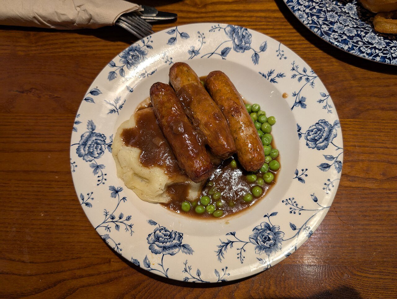 Representative photograph of Bangers and Mash. The photograph includes peas not included in this draft.