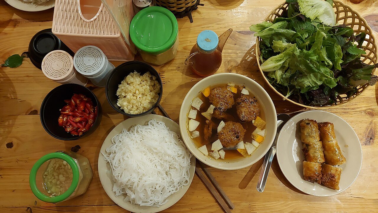 Representative photograph of Bun Cha. The photograph includes spring rolls and extra herbs not included in this draft.