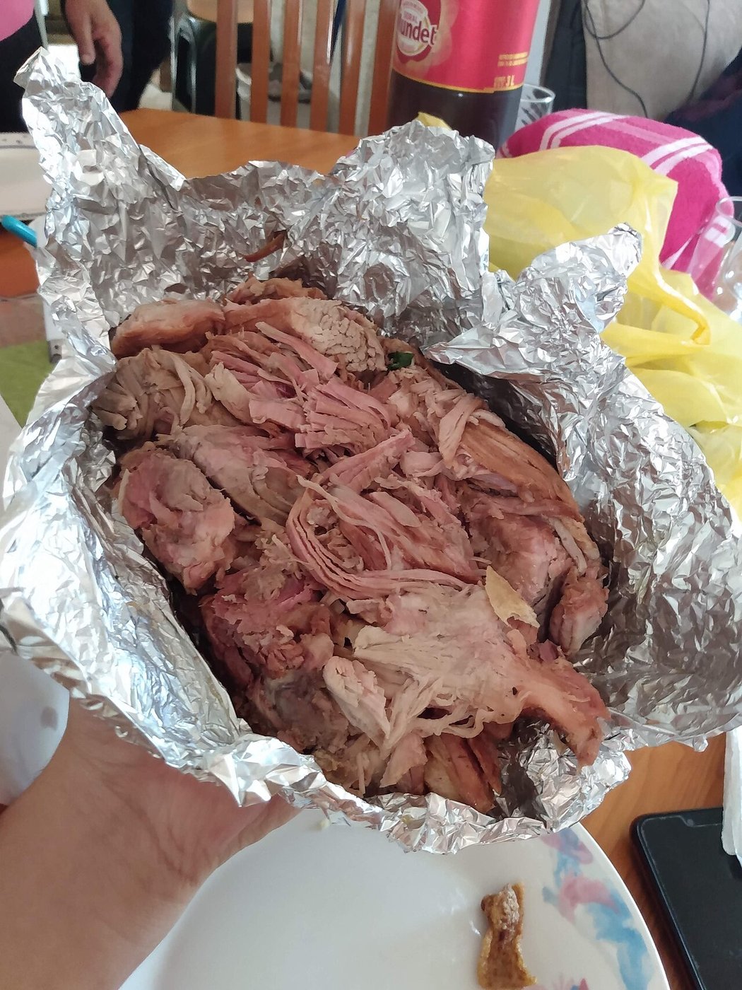 Representative photograph of Carnitas. The photograph shows cooked carnitas packed in foil before plating.