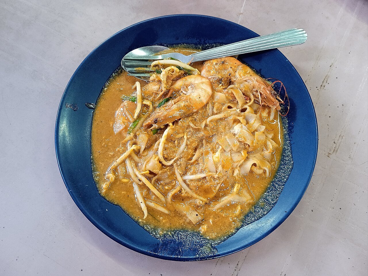 Representative photograph of Char Kway Teow. The photograph shows a wetter regional serving than this stir-fried draft.