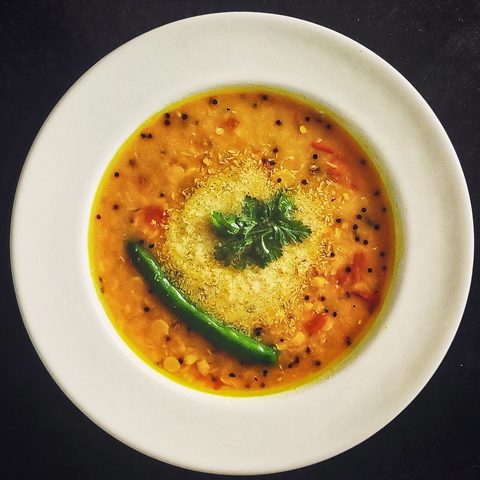 Yellow Bengali chana dal topped with coconut, spices and green chili