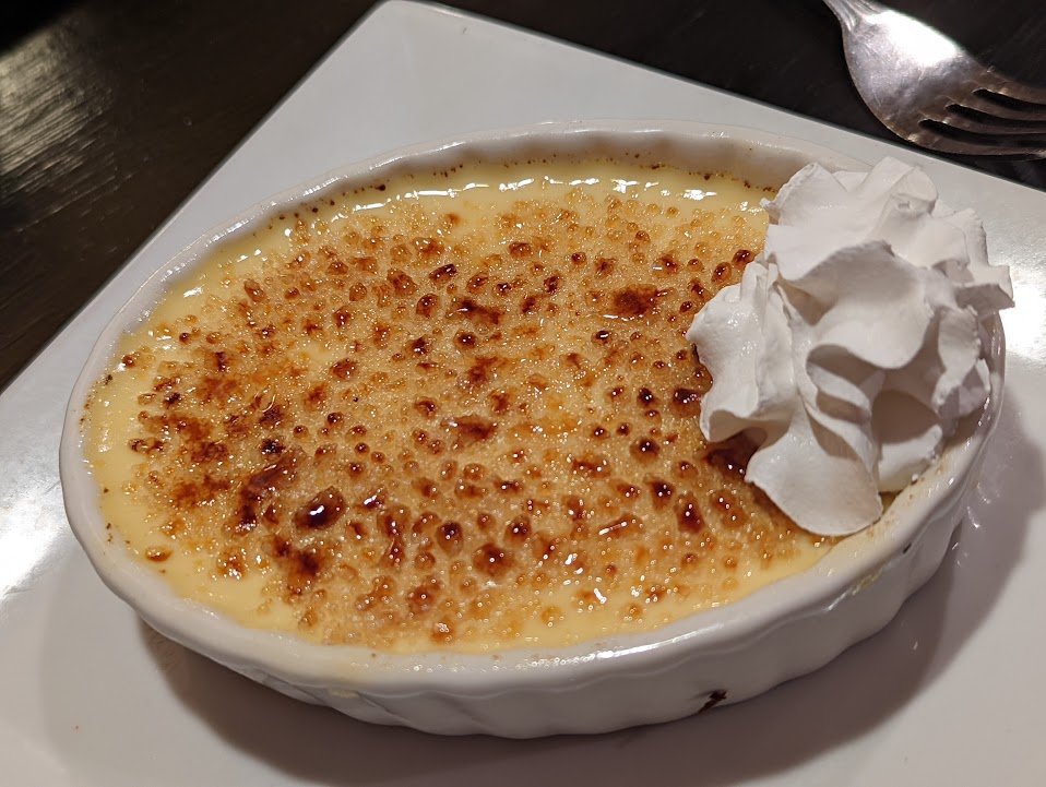 Representative photograph of Creme Brulee. The photograph includes whipped cream not included in this draft.