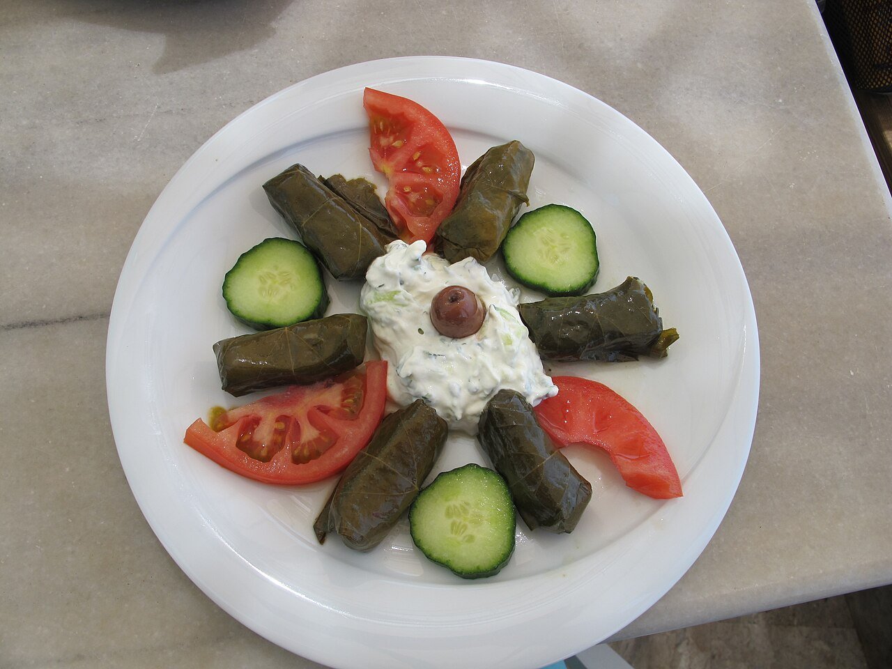 Representative photograph of Dolmades. The photograph includes yogurt and salad garnishes not included in this draft.