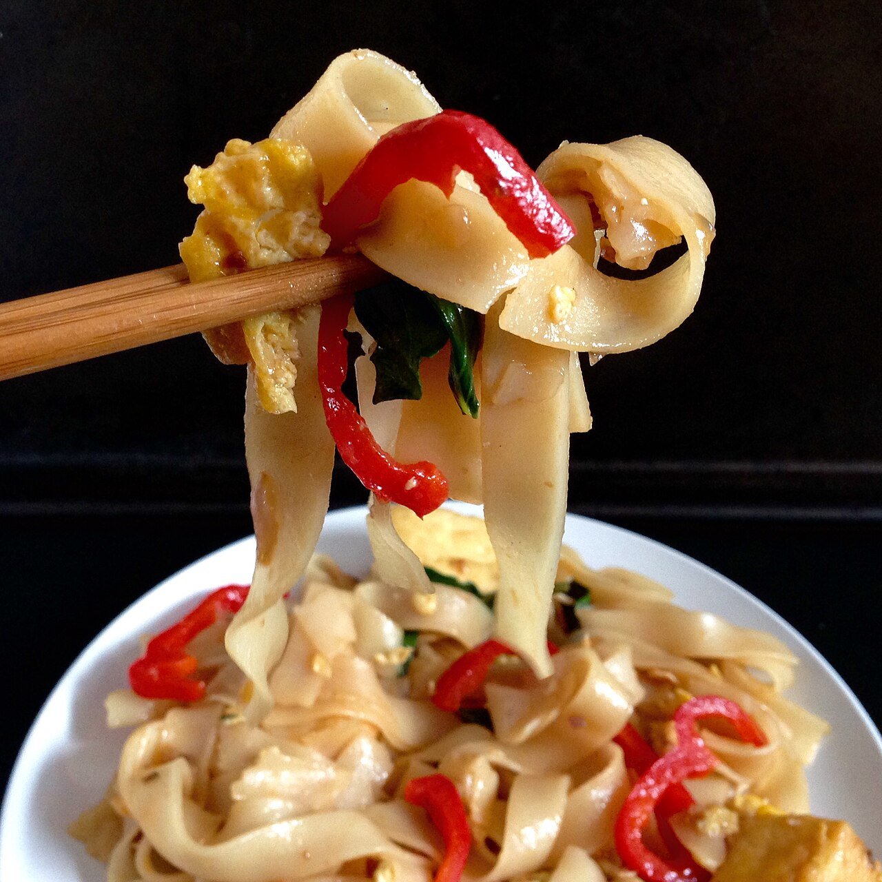 Representative photograph of Drunken Noodles. The photograph shows one lifted portion; the vegetables may differ from this draft.