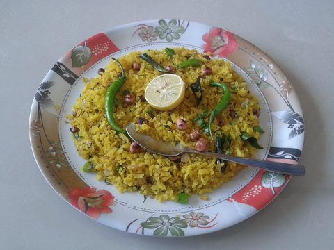 Yellow poha with peanuts, curry leaves, whole green chilies and lemon