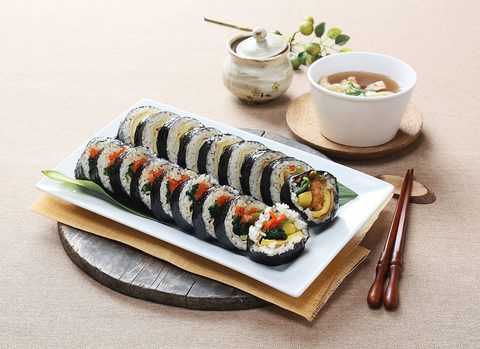 Representative photograph of Kimbap. The photographed rolls and side dishes include fillings that can differ from the vegetable-and-egg filling in this draft.