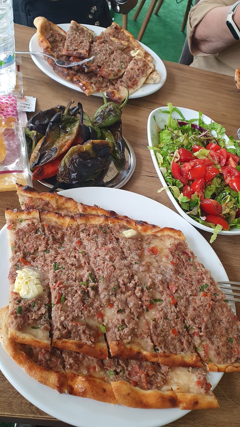 Representative photograph of Kiymali Pide. The photograph includes other dishes in the background; this draft makes only the minced-meat pide.