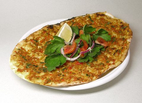 Representative photograph of Lahmacun. The photograph includes lemon and salad garnish not included in this draft.
