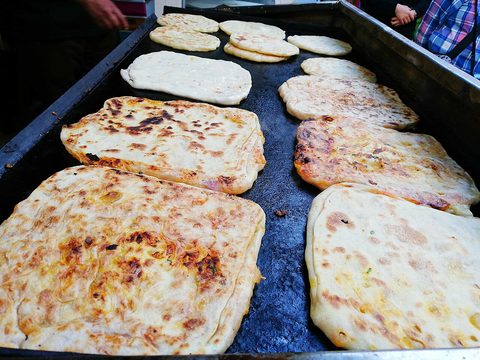 Representative photograph of Msemen. The photograph shows msemen on a cooking griddle.