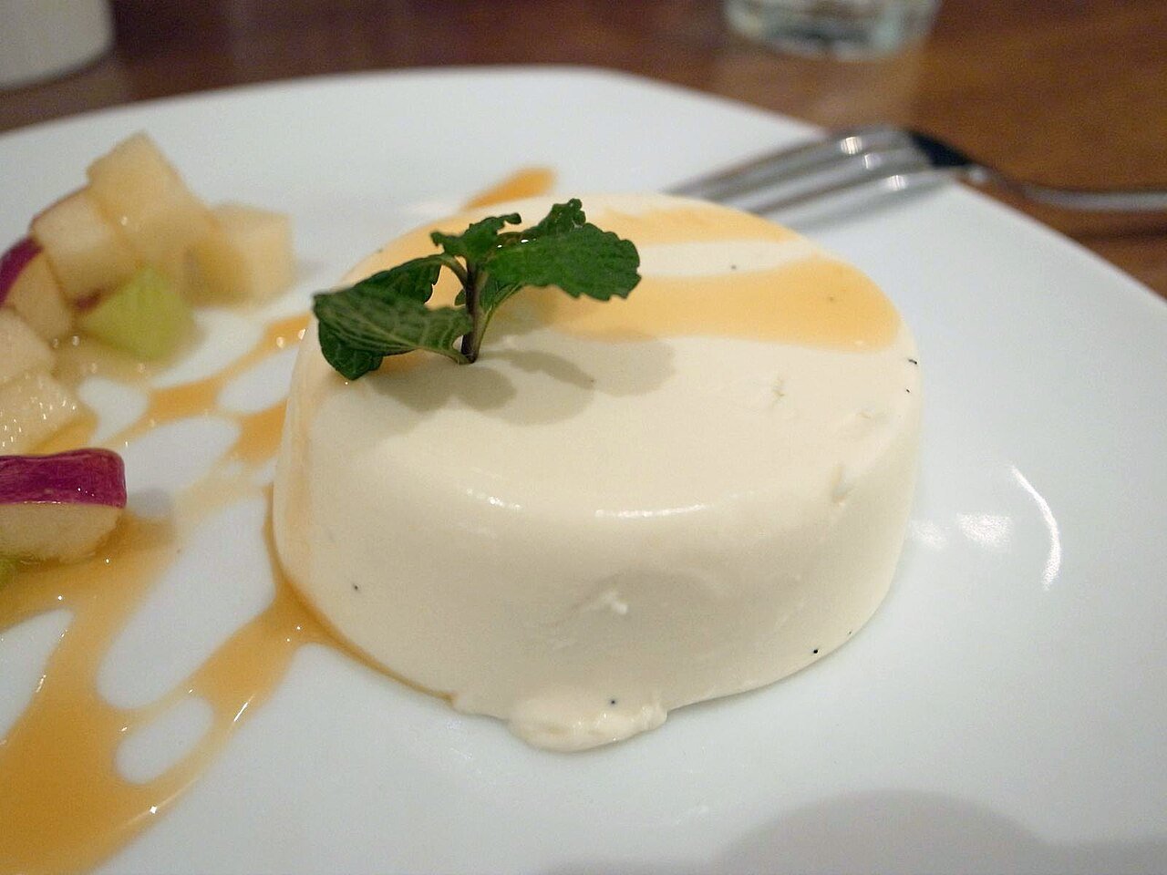 Representative photograph of Panna Cotta. The photograph includes fruit, sauce and mint garnish not included in this draft.
