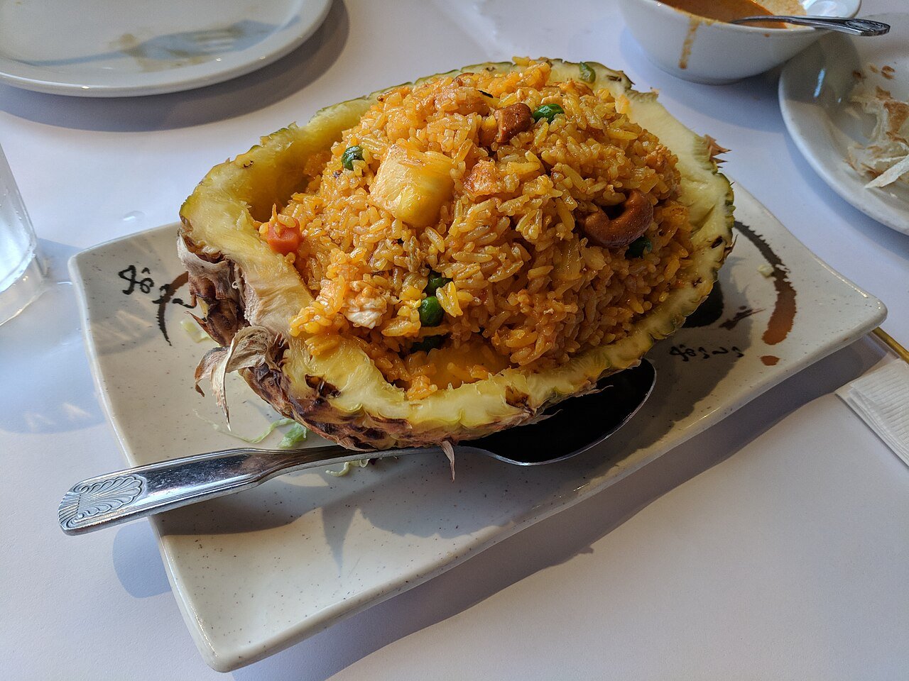 Representative photograph of Pineapple Fried Rice. The photo serves rice in a pineapple shell; this draft uses pineapple chunks without a shell serving bowl.