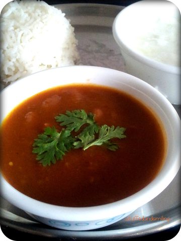 Kidney-bean curry with coriander in a bowl, rice and yogurt behind